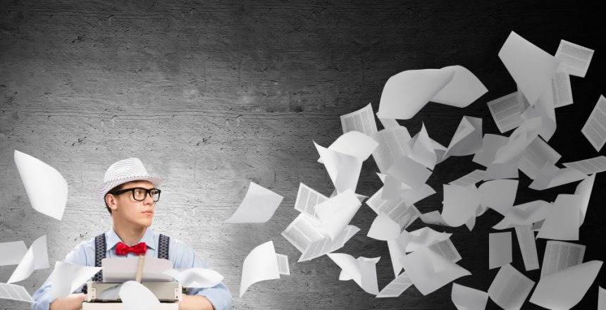 Young,Man,Writer,In,Hat,And,Eyeglasses,Using,Typing,Machine